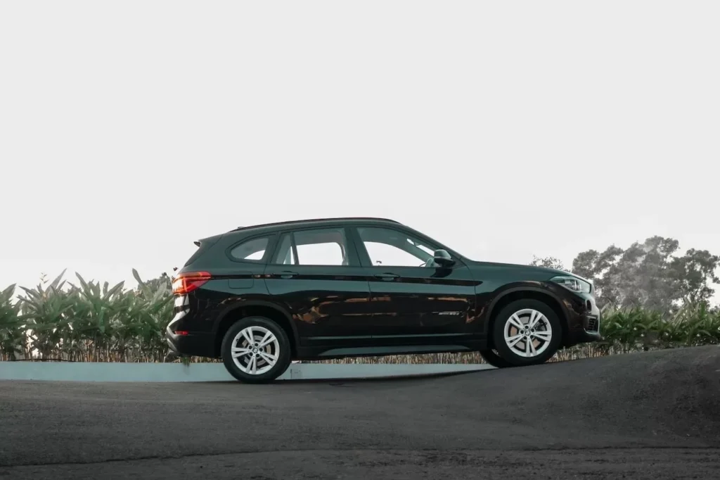 Elegant black SUV parked on a serene road with greenery in the background