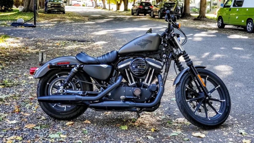 Black and silver cruiser motorcycle parked on gray concrete road during daytime