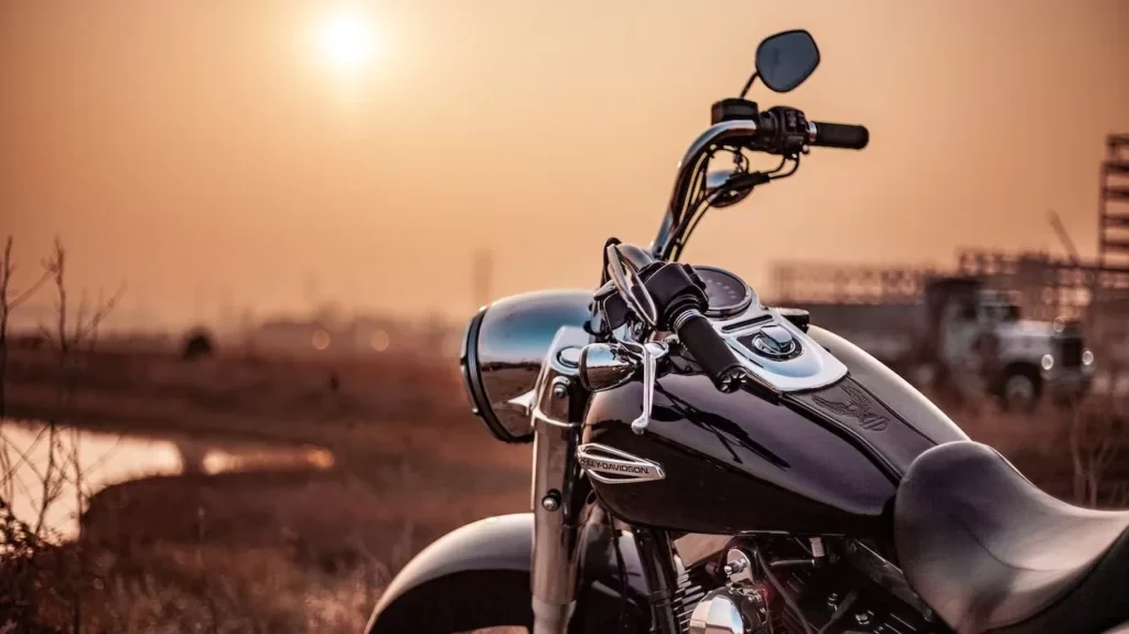 Harley Davidson motorcycle parked outdoors at sunset, capturing the warm glow and serene environment