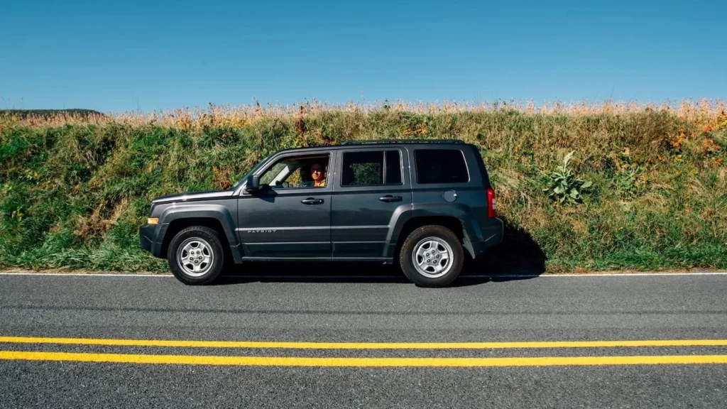 Black SUV on gray asphalt road during daytime