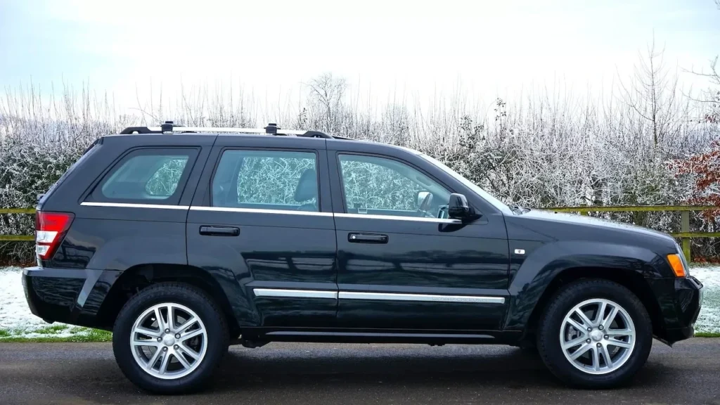 A black SUV parked outdoors on a snowy road surrounded by a winter landscape