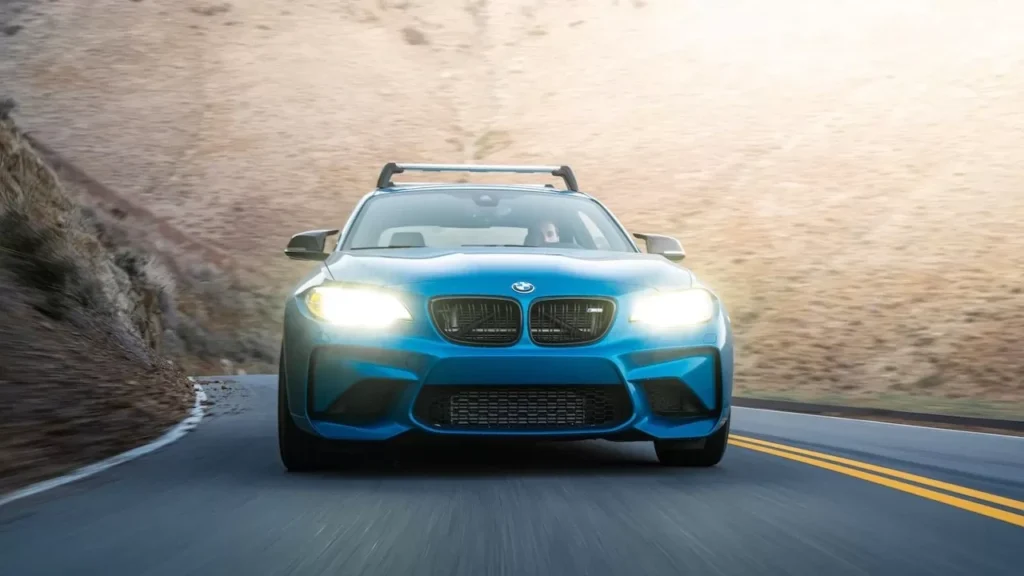 blue luxury car driving on a winding mountain road, showcasing speed and elegance