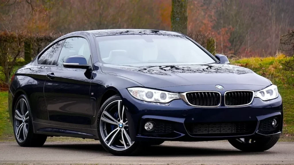 Stylish blue luxury coupe parked outdoors in autumn landscape