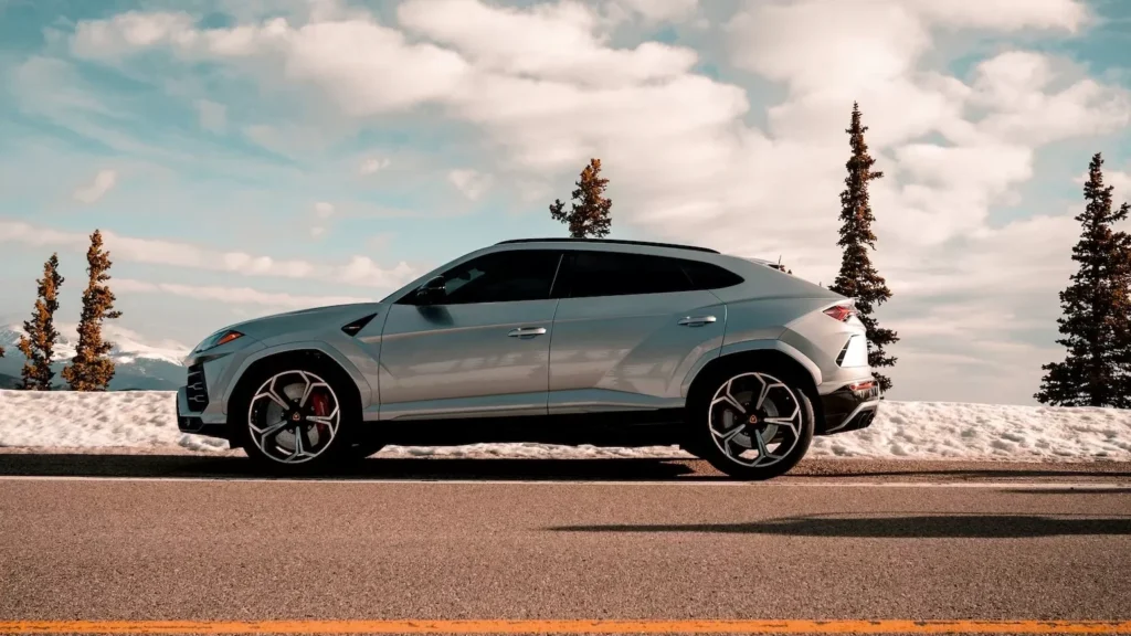 Blue coupe on gray asphalt road under white clouds and blue sky during daytime