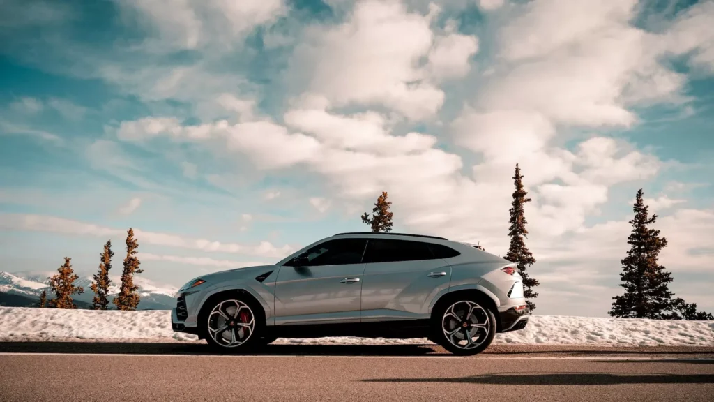 Blue coupe on gray asphalt road under white clouds and blue sky during daytime