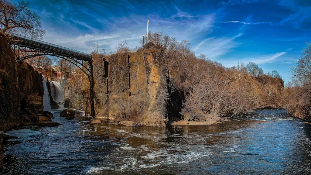 Brown concrete building near river under blue sky during daytime