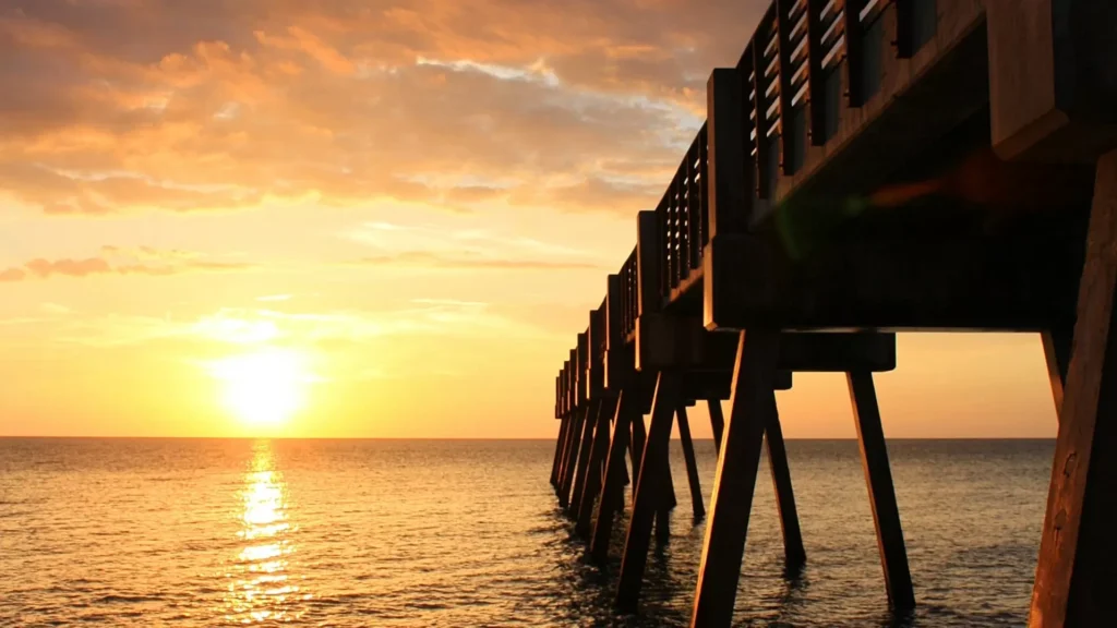 Brown wooden dock on sea during sunset