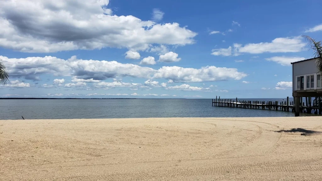 Brown wooden dock on sea under blue and white cloudy sky during daytime