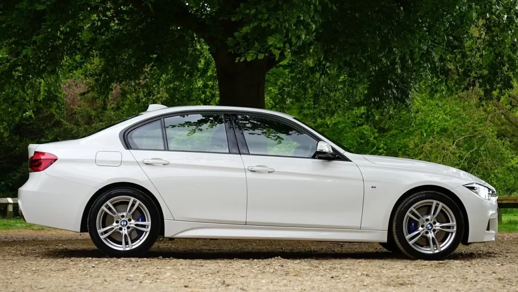 Photo of a white BMW surrounded by trees