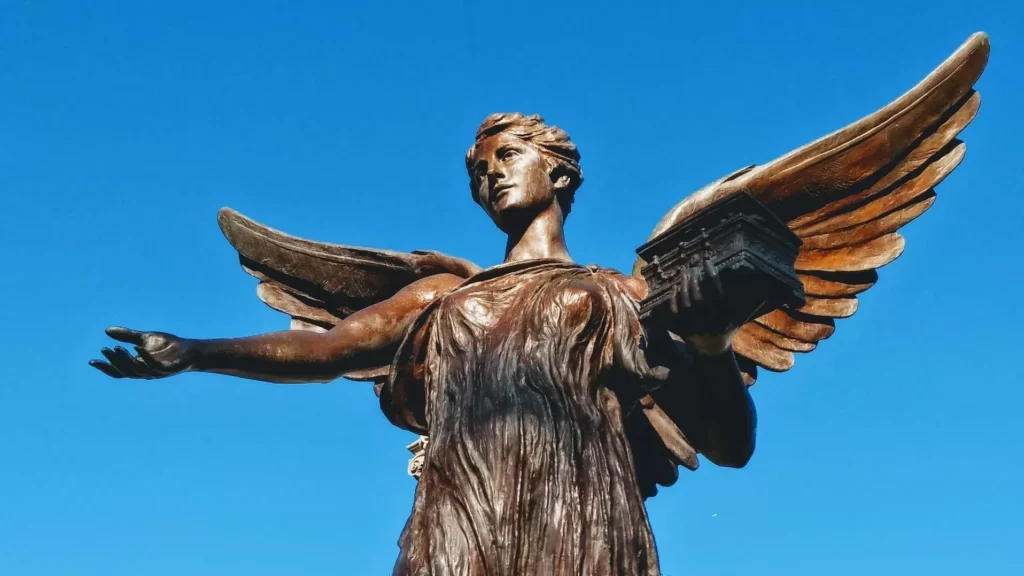 Female angel statue under a calm blue sky