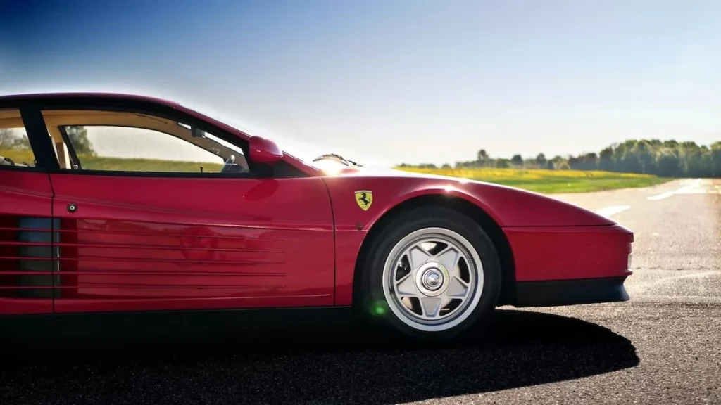 Close-up of a red sports car parked on an asphalt road under clear skies
