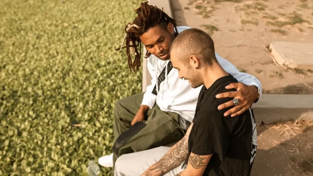 Two friends share a supportive moment outdoors, highlighting affection and companionship