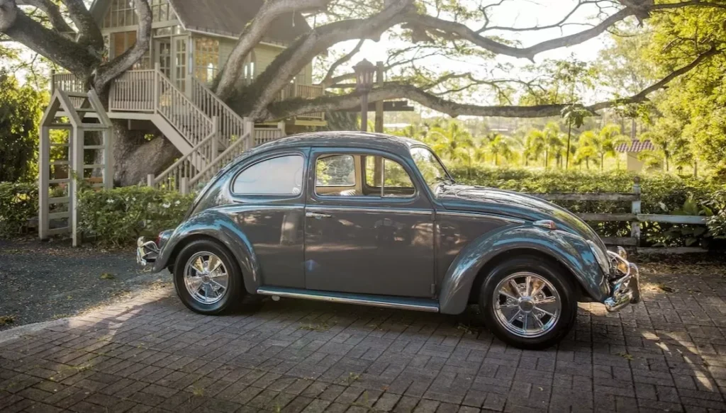 Vintage Volkswagen Beetle parked beside a charming treehouse, surrounded by lush greenery