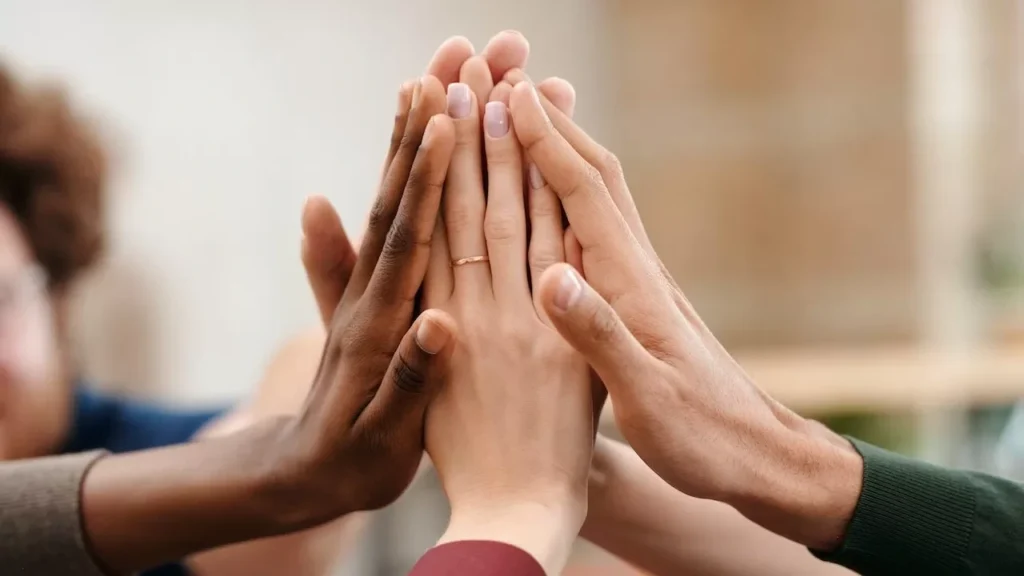 Close-up of diverse group hands high-fiving symbolizing teamwork and unity