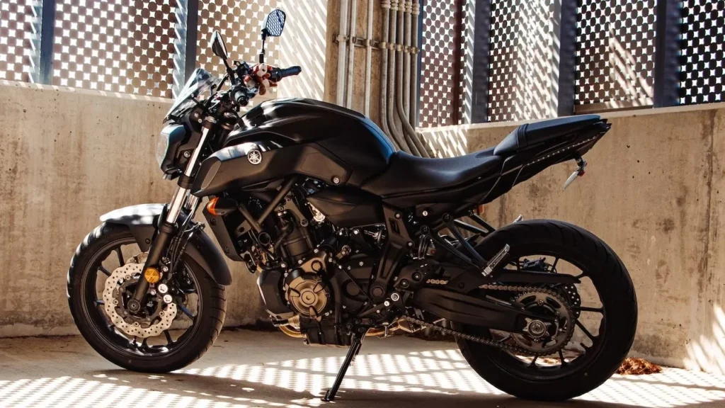 Elegant black motorcycle parked inside a concrete structure with dramatic shadows