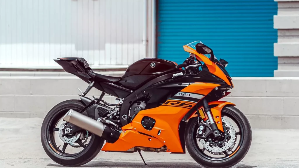 Orange and black sports bike parked beside blue and white building