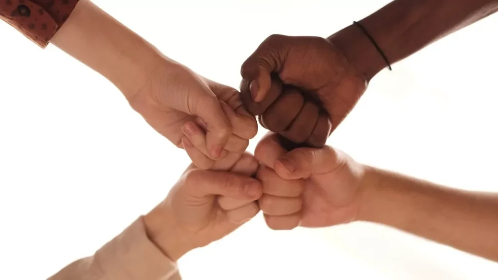 Close-up of diverse hands joining in a fist bump representing unity and teamwork