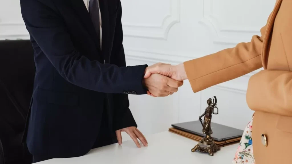 Two business professionals shaking hands in an office, showcasing agreement