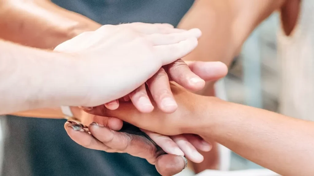 Diverse team members unite hands in a symbol of partnership and success