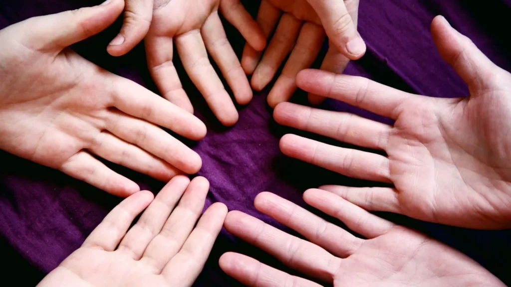 Persons left hand on purple textile