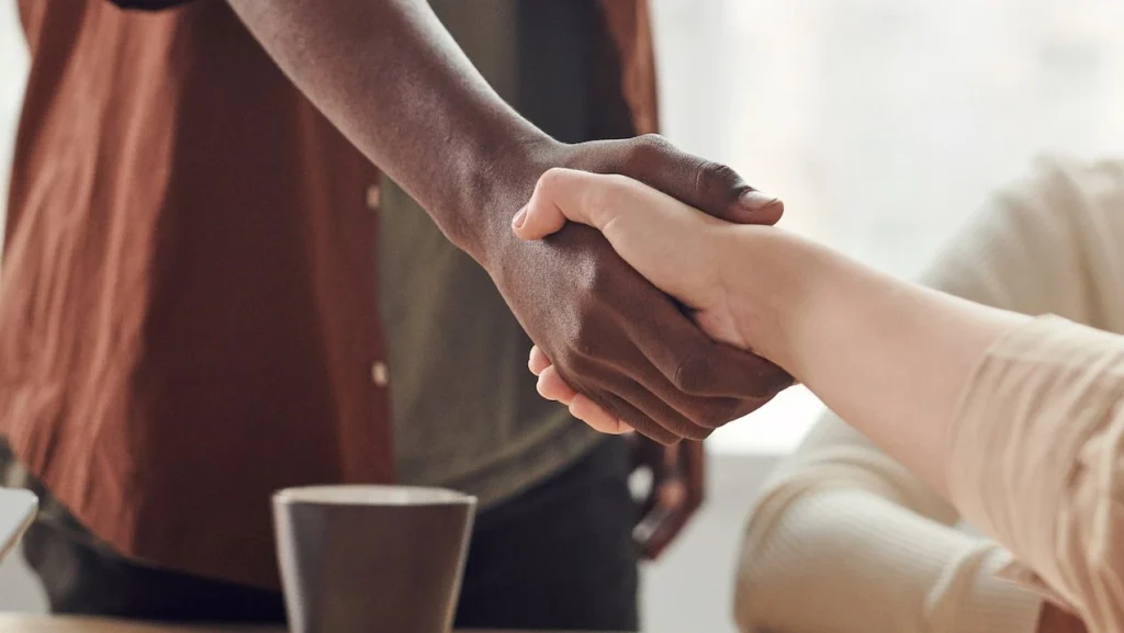 Two colleagues shaking hands in a business meeting, symbolizing cooperation and agreement