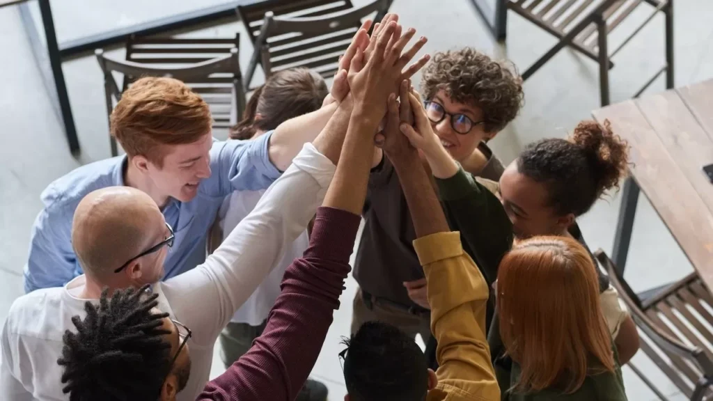 A diverse group of professionals high-fiving in a modern office