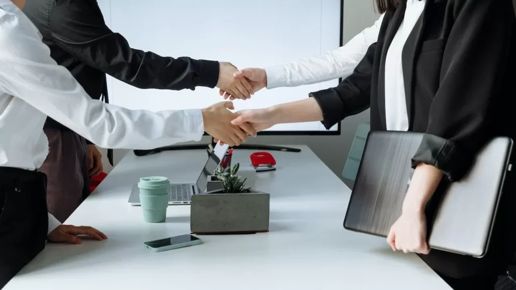 Professionals sealing a deal with a handshake across a conference table during a business meeting