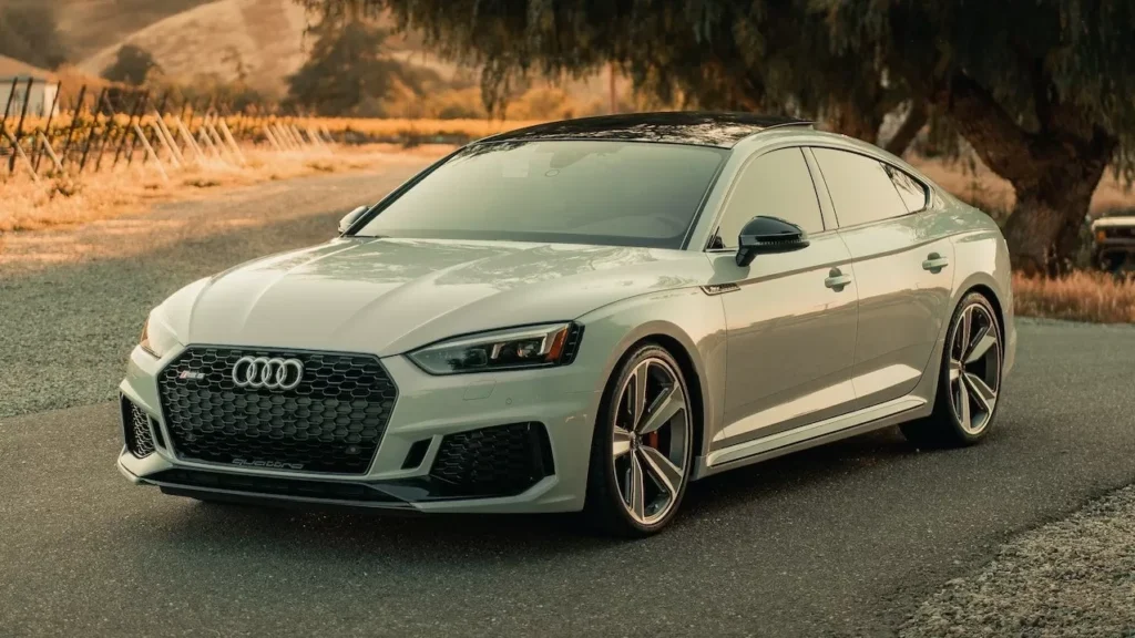 A premium Audi sedan parked on a picturesque road at sunset