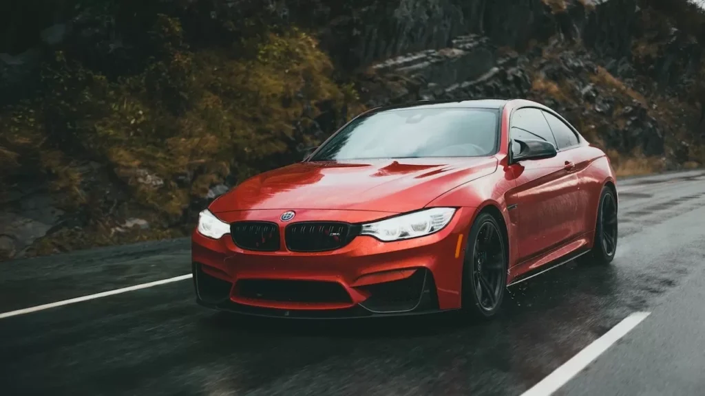 ed sports car driving on a wet road under cloudy skies, showing speed and luxury.