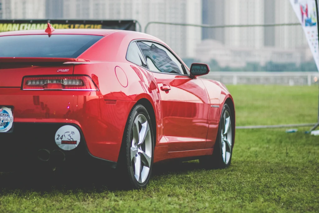 Dynamic red sports car captured outdoors with city skyline backdrop