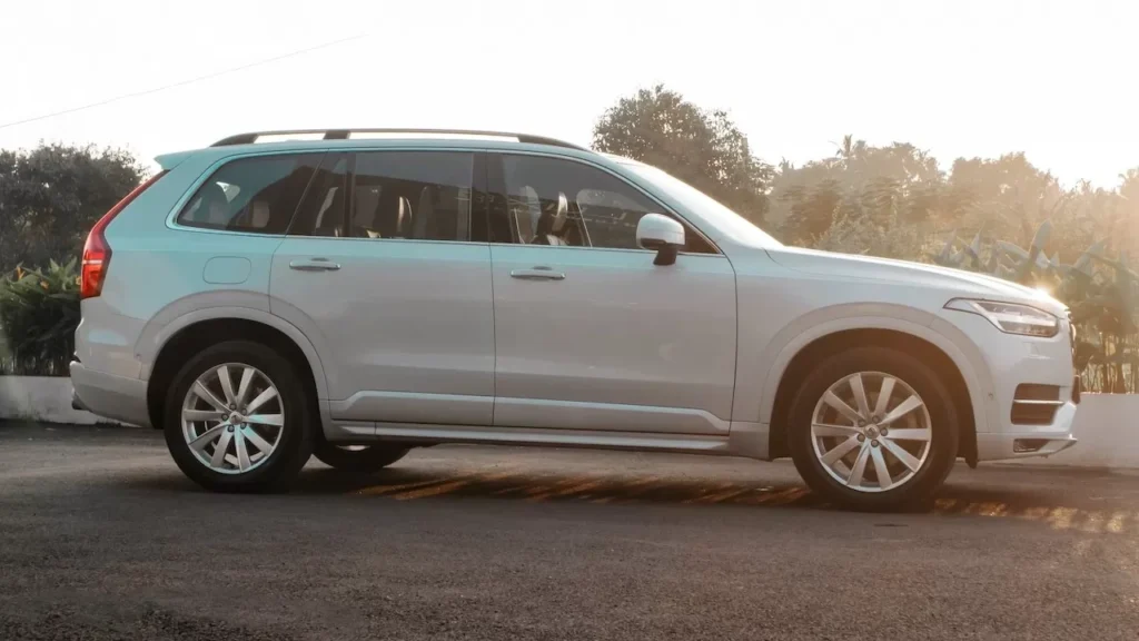 A stylish white luxury SUV captured in side view on a sunny day.