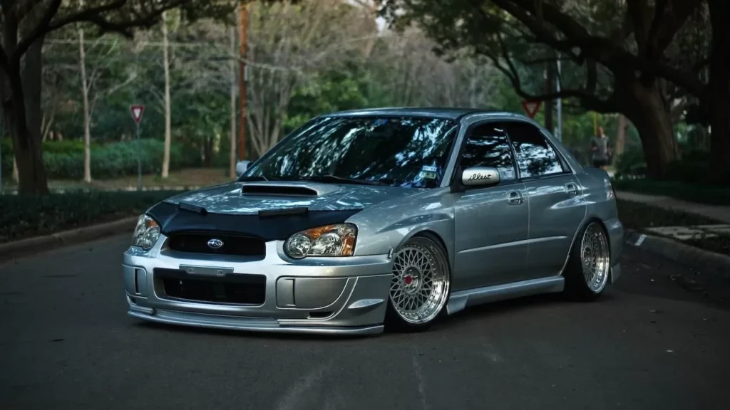 Stylish modified silver sedan parked on a serene urban street