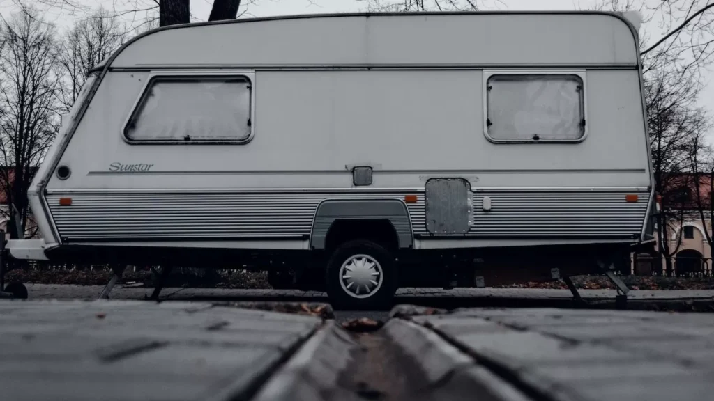 Cozy vintage caravan parked outdoors amidst autumn foliage