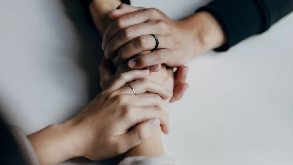 Two people holding hands on table in comfort