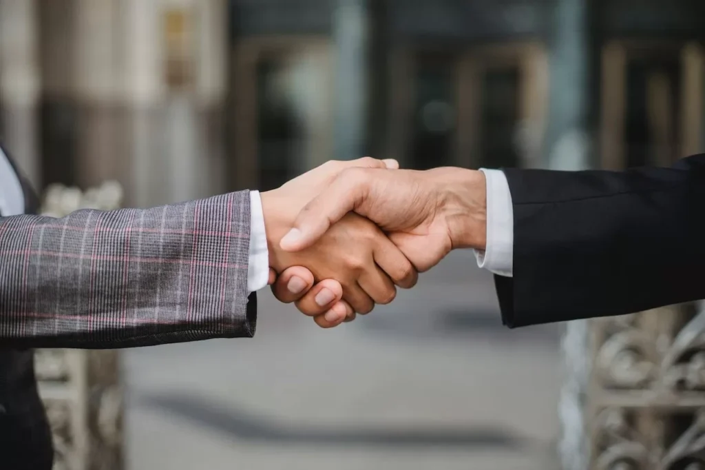 A close-up of two businesspeople shaking hands, symbolizing cooperation and partnership
