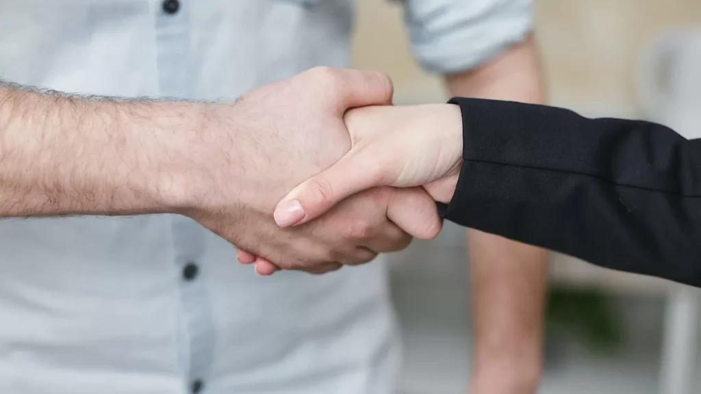 Close-up of two individuals shaking hands symbolizing business agreement and partnership