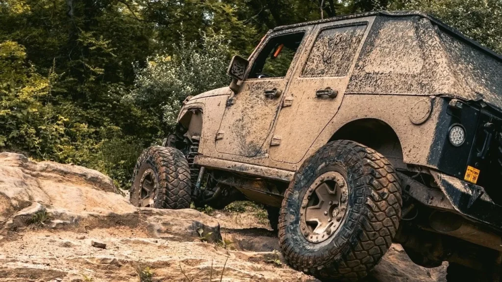 SUV tackling rocky terrain in a muddy off-road adventure, showcasing its durability and capability