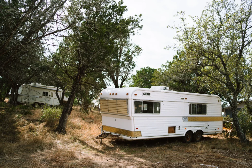 Vintage camper trailers set amidst trees in a peaceful Texas forest scene