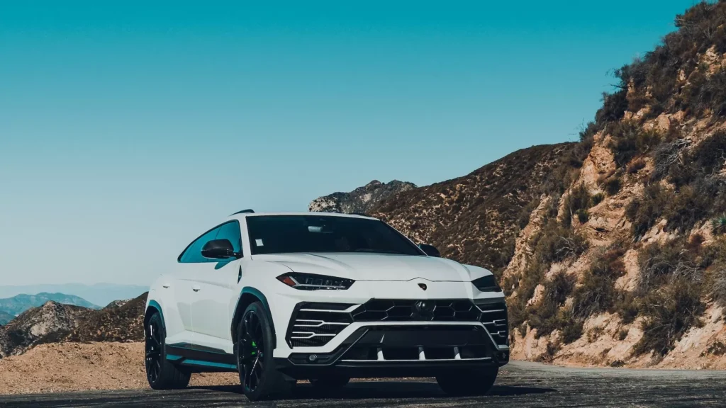 White car on brown dirt road during daytime