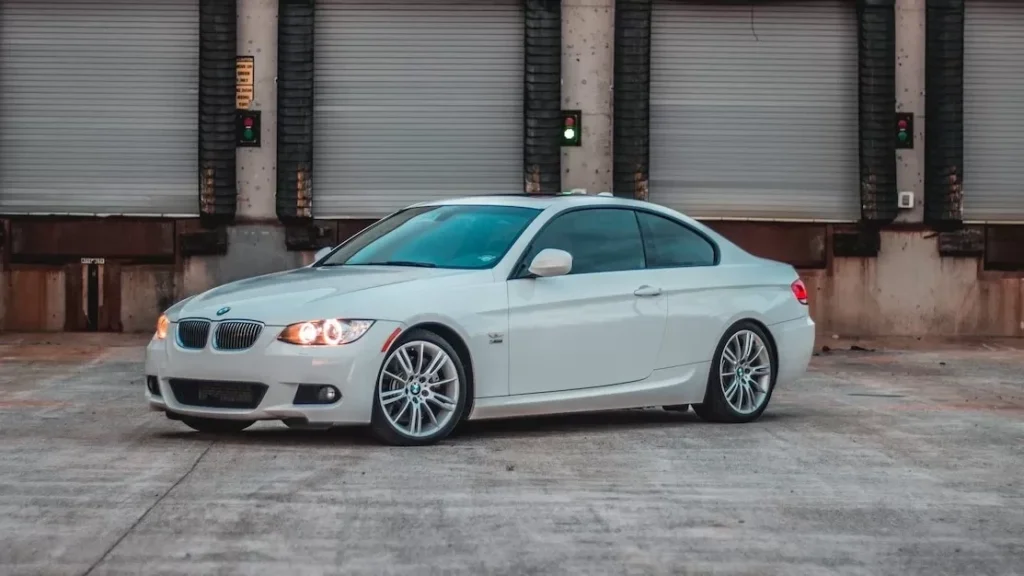 A sleek BMW parked in front of industrial loading docks, showcasing elegance