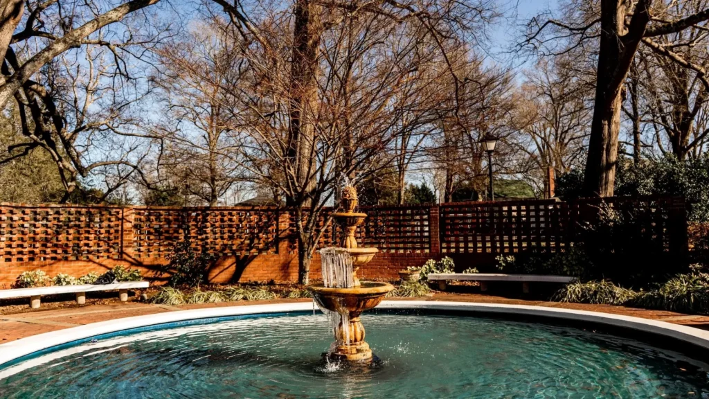 A fountain in a park with trees in the background