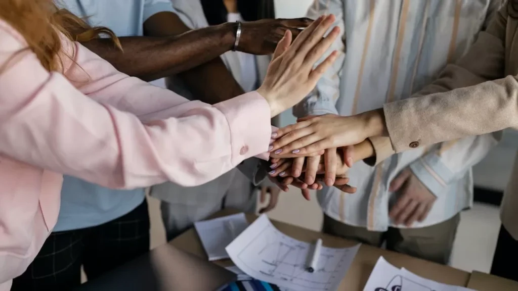 Diverse team members putting hands together in an office