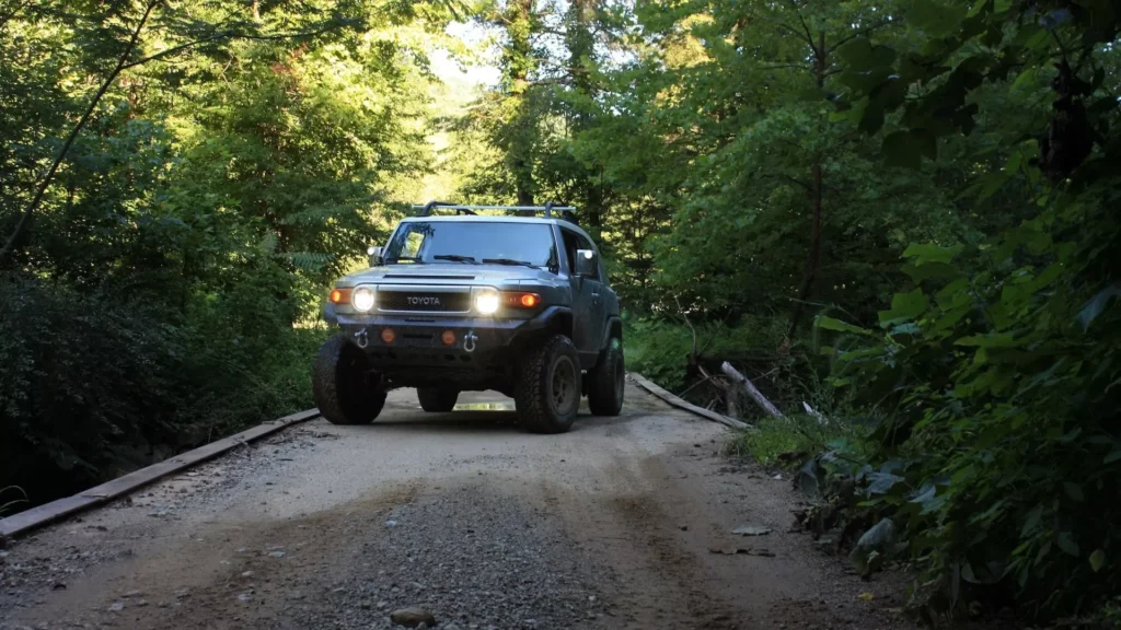 Black Chevrolet crew cab pickup truck parked on dirt road