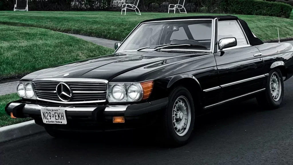 black Mercedes Benz car parked in front of white and brown house