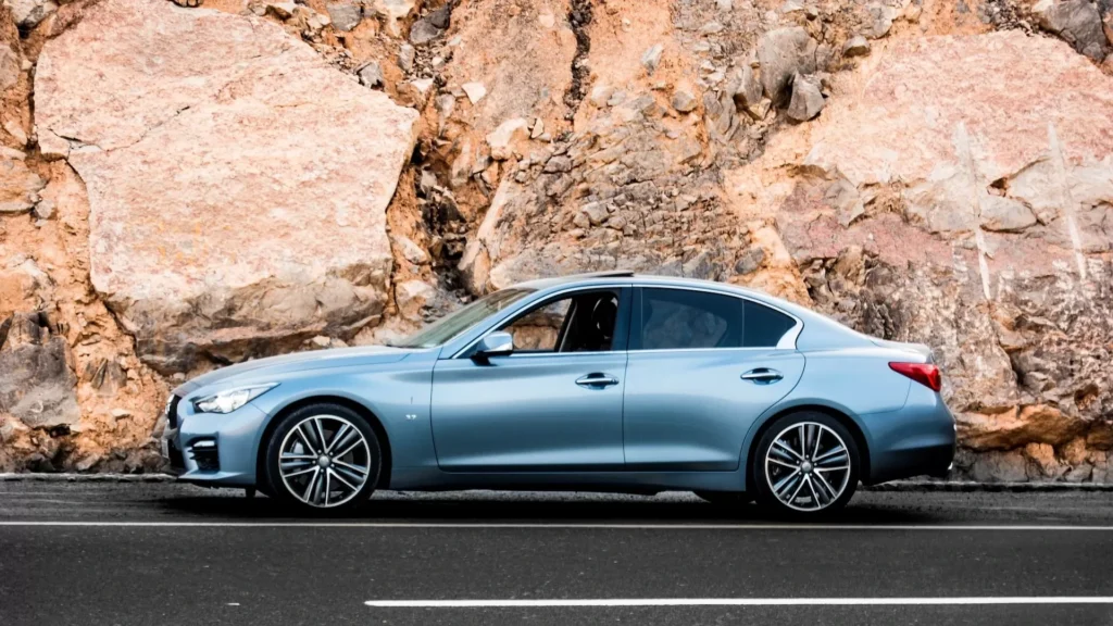 Blue sedan parked on the road during daytime