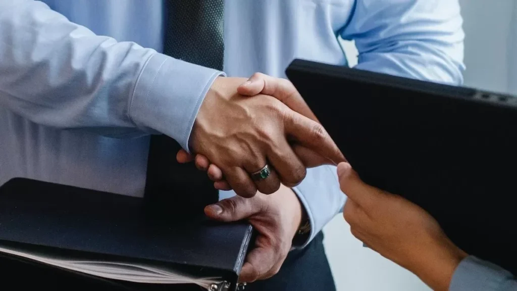 Business handshake between colleagues in a formal office meeting setting