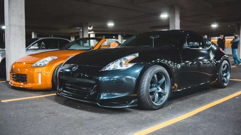 Black and orange luxury sports cars parked in a modern underground garage