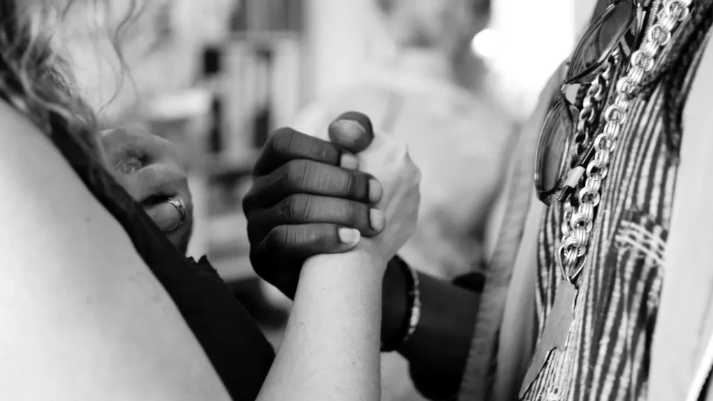 Grayscale photo of man and woman holding their hands