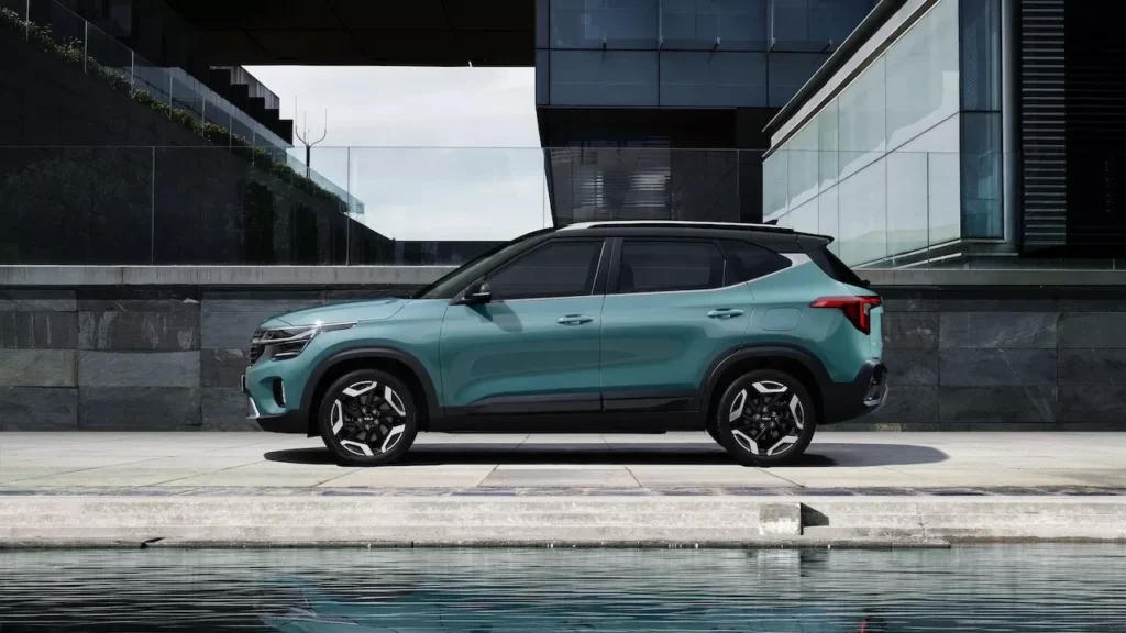 A sleek green SUV parked in front of a contemporary building beside a water feature