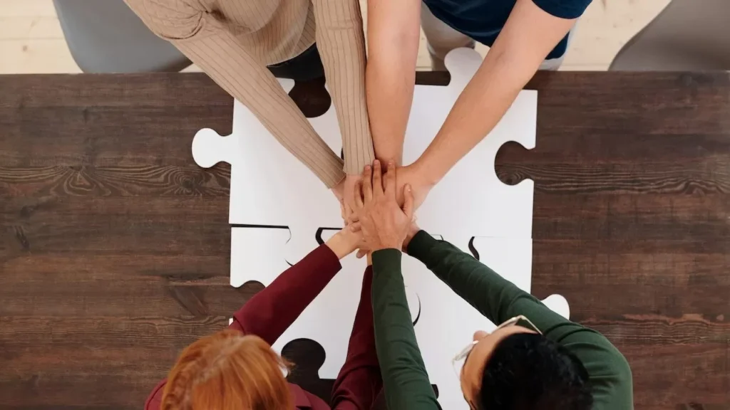 Engaging image of diverse people's hands coming together on puzzle pieces